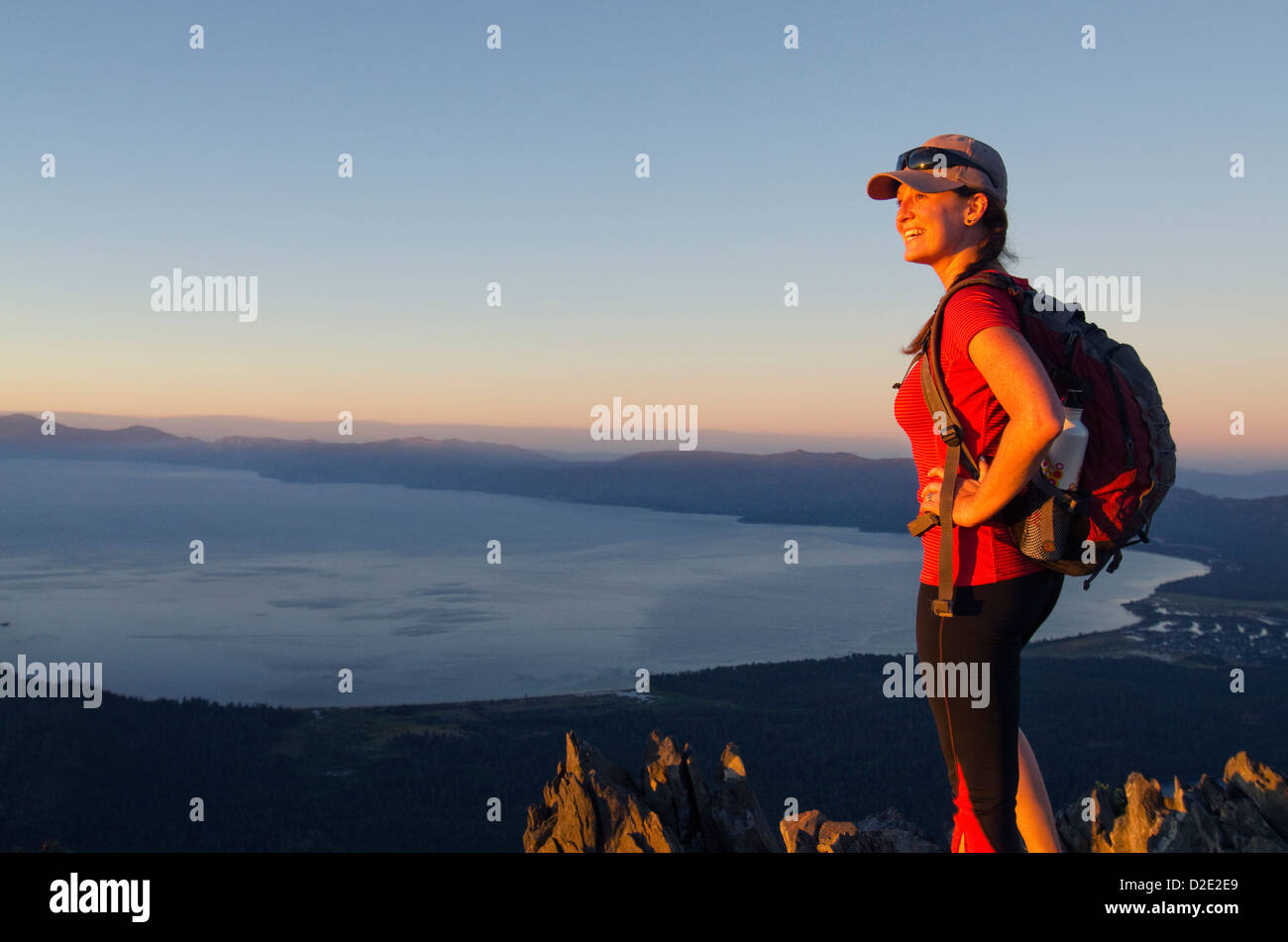 Un female hiker bénéficie d'une vue spectaculaire du lac Tahoe au coucher du soleil depuis le sommet du mont Tallac, CA. Banque D'Images