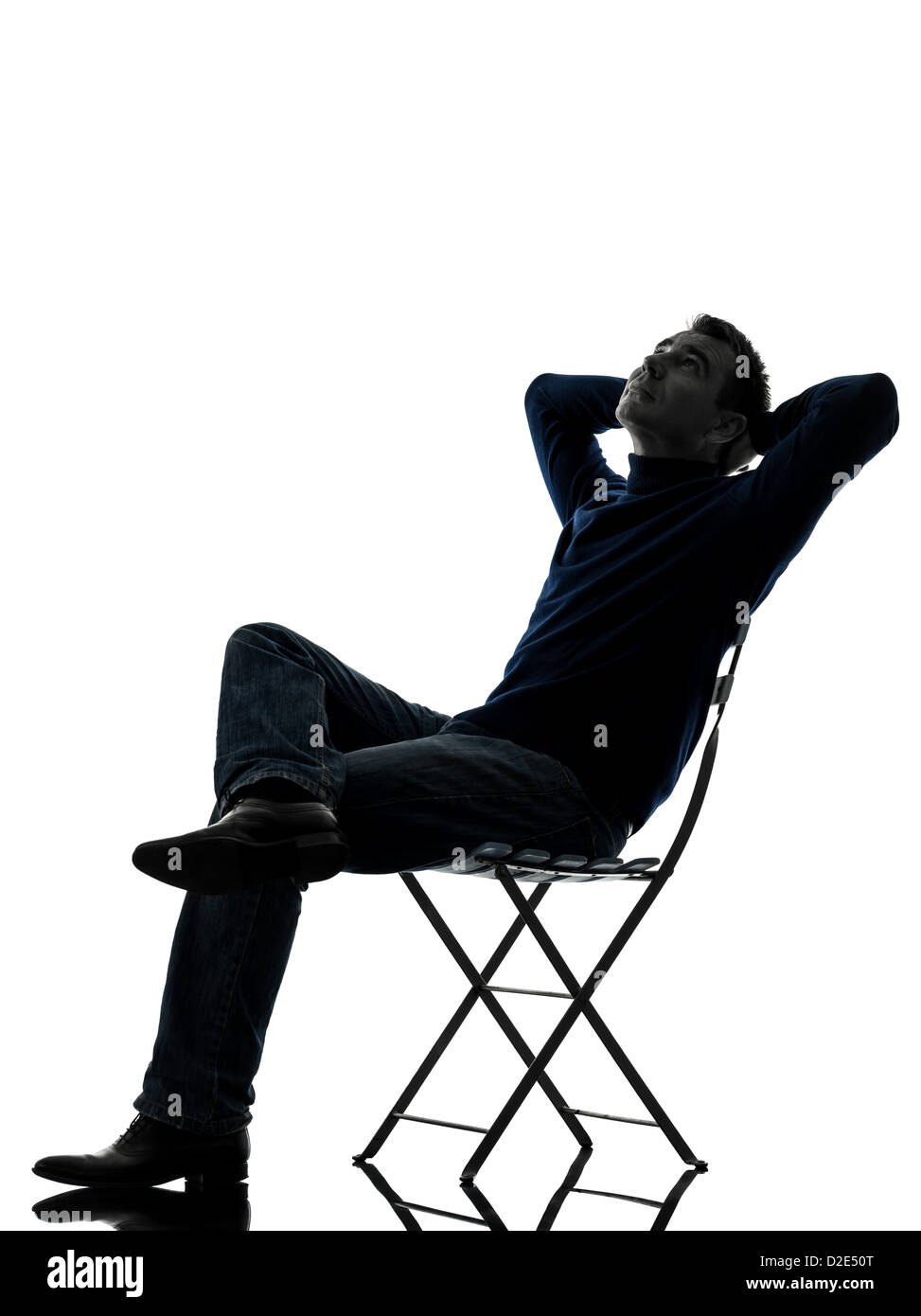 Un homme assis en appui à la pleine longueur jusqu'en silhouette studio isolé sur fond blanc Banque D'Images