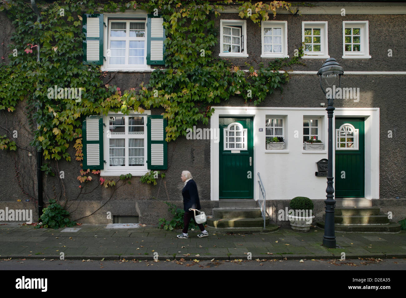 Essen, Allemagne, femme plus âgée, en face de la rangée de maisons dans la ville de jardin Margarethenhoehe Banque D'Images