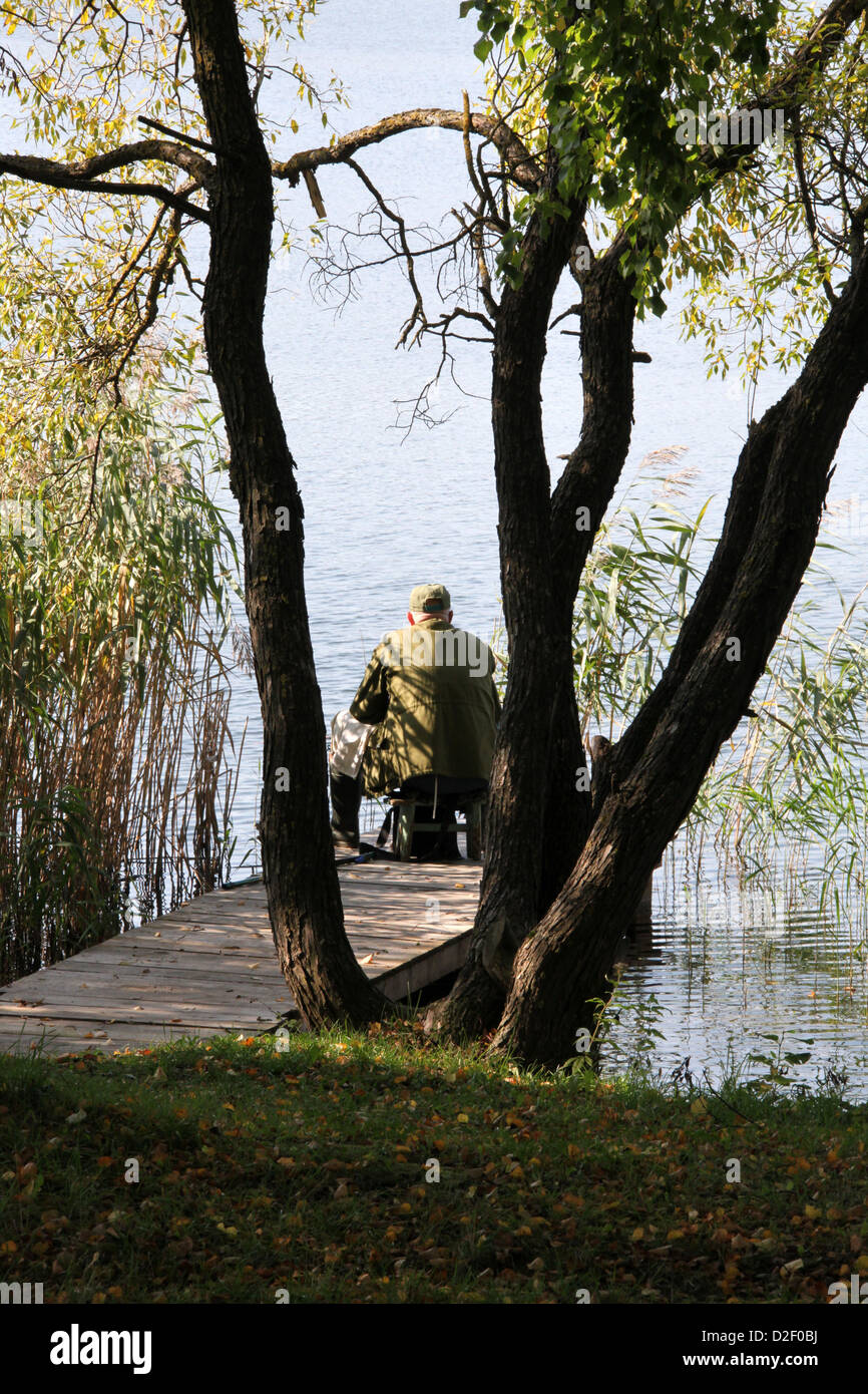 Un pêcheur au bord du lac dans la station balnéaire de Lituanie Trakai Banque D'Images