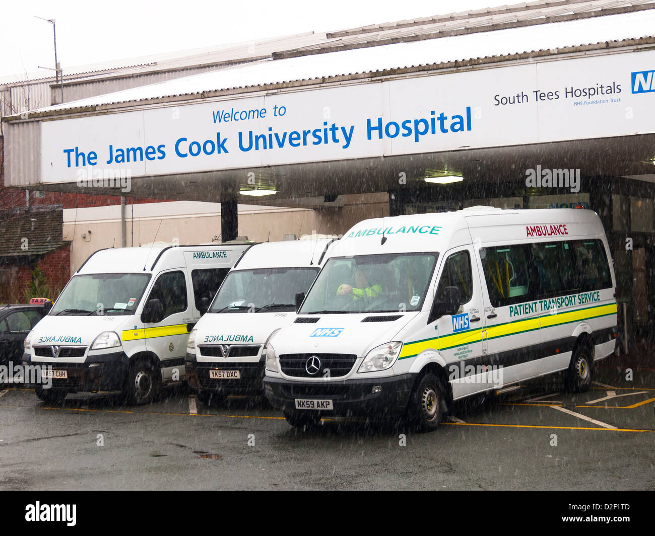 Service d'ambulances pour le transport du patient à l'entrée principale de l'hôpital de l'Université James Cook Middlesbrough en hiver Banque D'Images