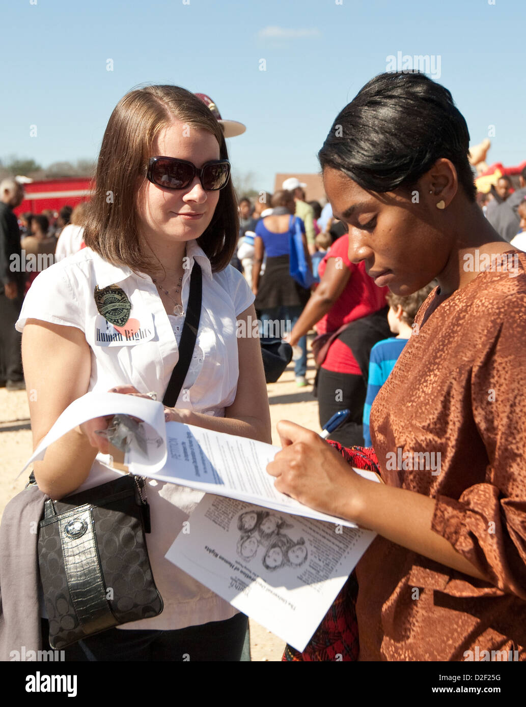 Janvier 21st, 2013 : Blanc femme demande afro-américain à signer pétition en faveur des droits de l'homme à un festival extérieur MLK Jr. Banque D'Images