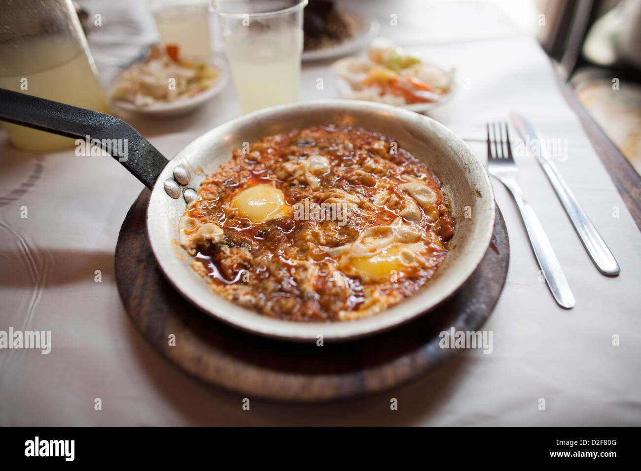 Poêle de fer de shakshouka servi au Dr Shakshuka à Jaffa, près de Tel Aviv en Israël. Le plat est composé d'œufs, de tomates et d'épices. Banque D'Images