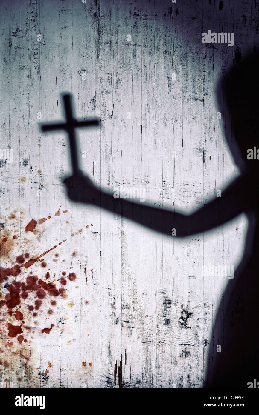 Ombre d'une personne avec une croix sur un mur blanc sanglante Banque D'Images