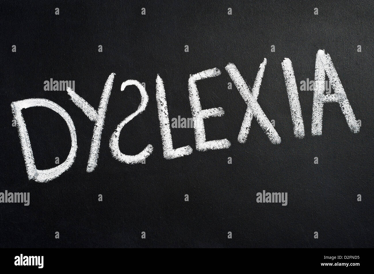 Tableau noir avec le mot dyslexie écrit dessus en blanc de craie avec le S à l'envers Banque D'Images