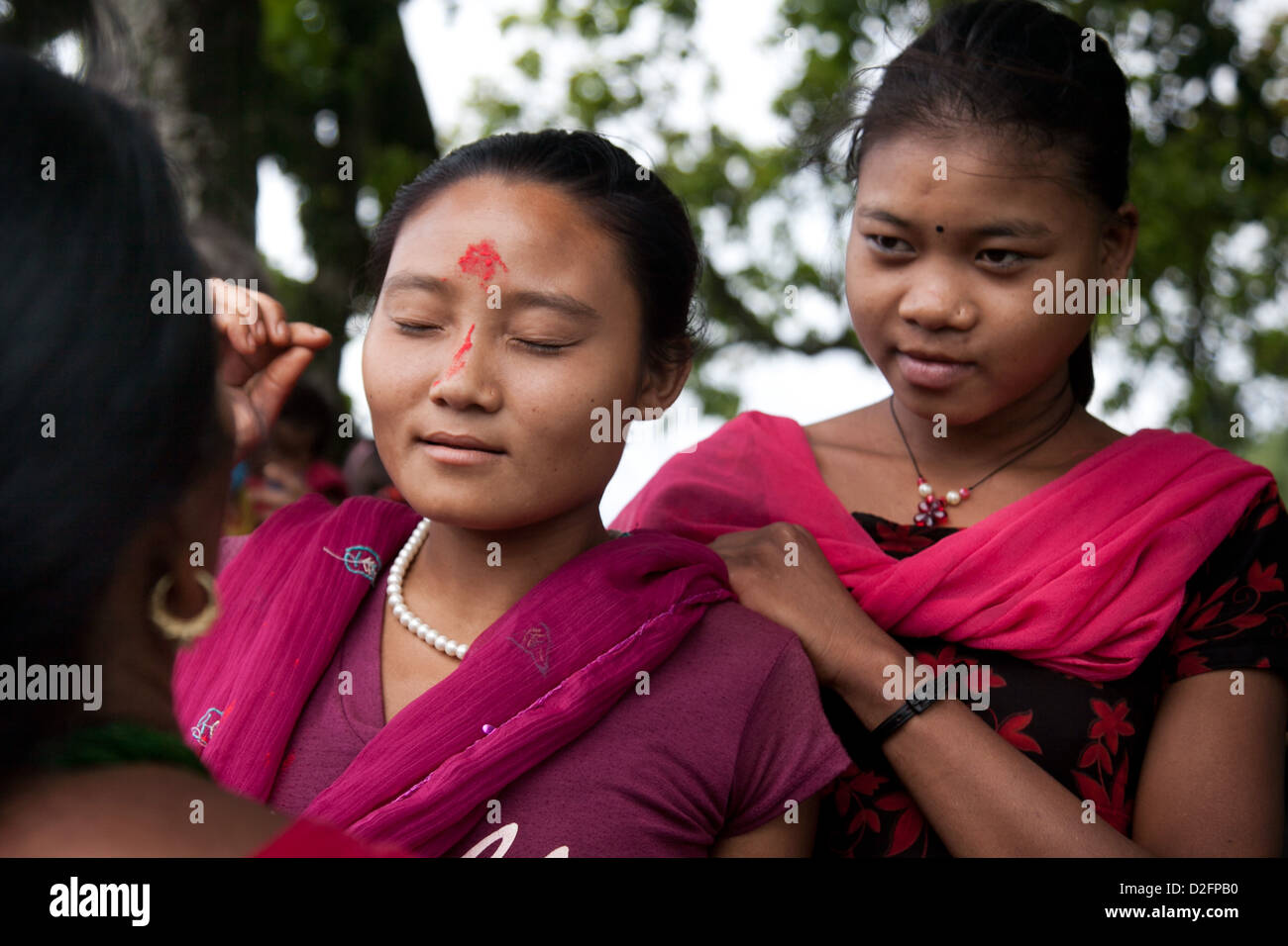 Sanamaya Chepang est de donner à un couple des Tika jeunes femmes à une collecte locale jusqu'à la montagne. Banque D'Images