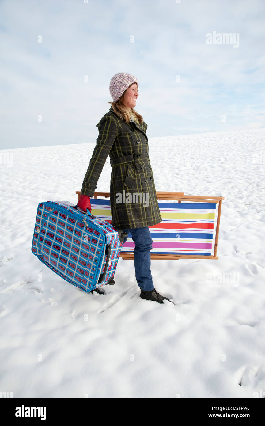 Maison de vacances hiver vacancier de marcher à travers champ couvert de  neige & valise de transport un transat Photo Stock - Alamy
