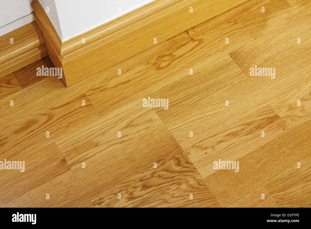 Close up montrant certains planchers laminés et mdf imitation bois plinthe dans maison nouvellement construite Banque D'Images