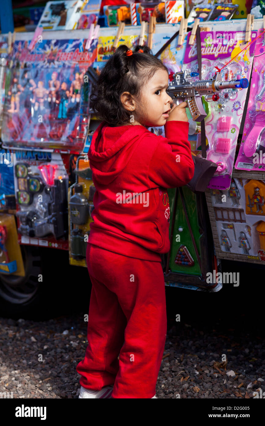 Une petite fille joue avec un pistolet jouet à la Fiesta de San Sebastian où les Adejeros apporter leurs animaux pour être heureux Banque D'Images