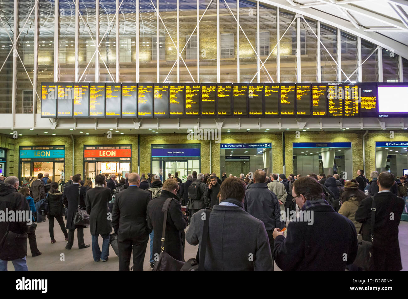 Les banlieusards de gens étudient les conseils de départ plein d'annulations retards des trains à la gare de Kings Cross, London, UK dans l'heure de pointe Banque D'Images