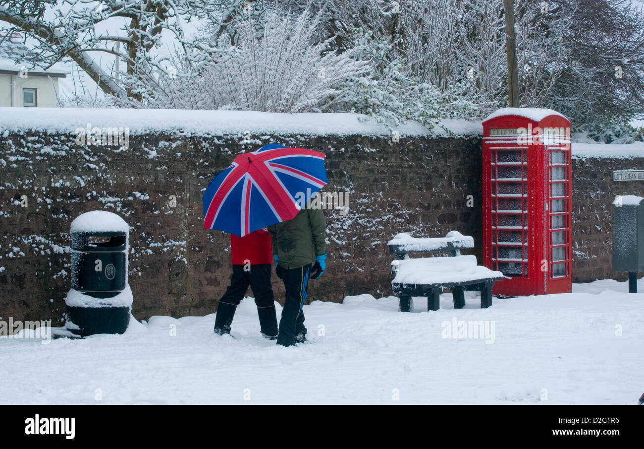 Le Gloucestershire, Royaume-Uni. 23 janvier 2013. La neige scène avec phone box et union jack umberella. Banque D'Images