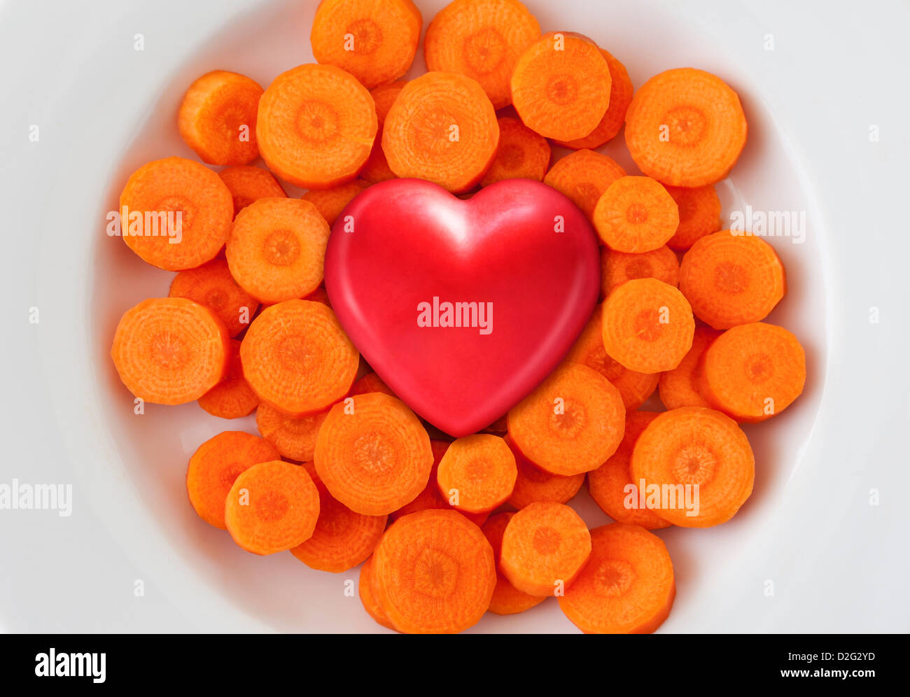 Coeur rouge sur fond blanc plat de carottes fraîches, une alimentation saine, une alimentation saine notion Banque D'Images