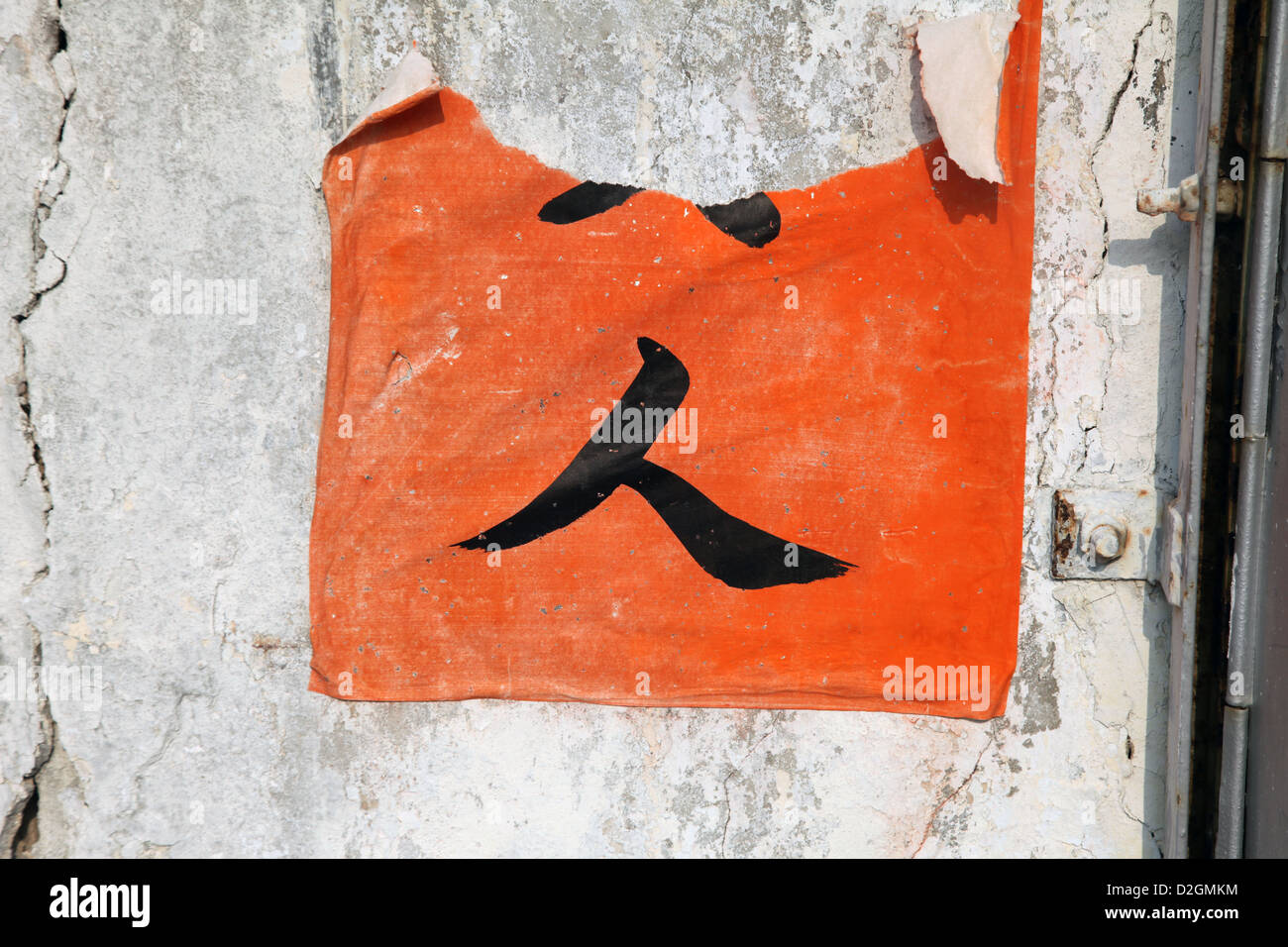 C'est une photo d'une peinture de caractères chinois sur un morceau de l'affiche qui est collée contre un mur détruit. Le mot signifie personne Banque D'Images