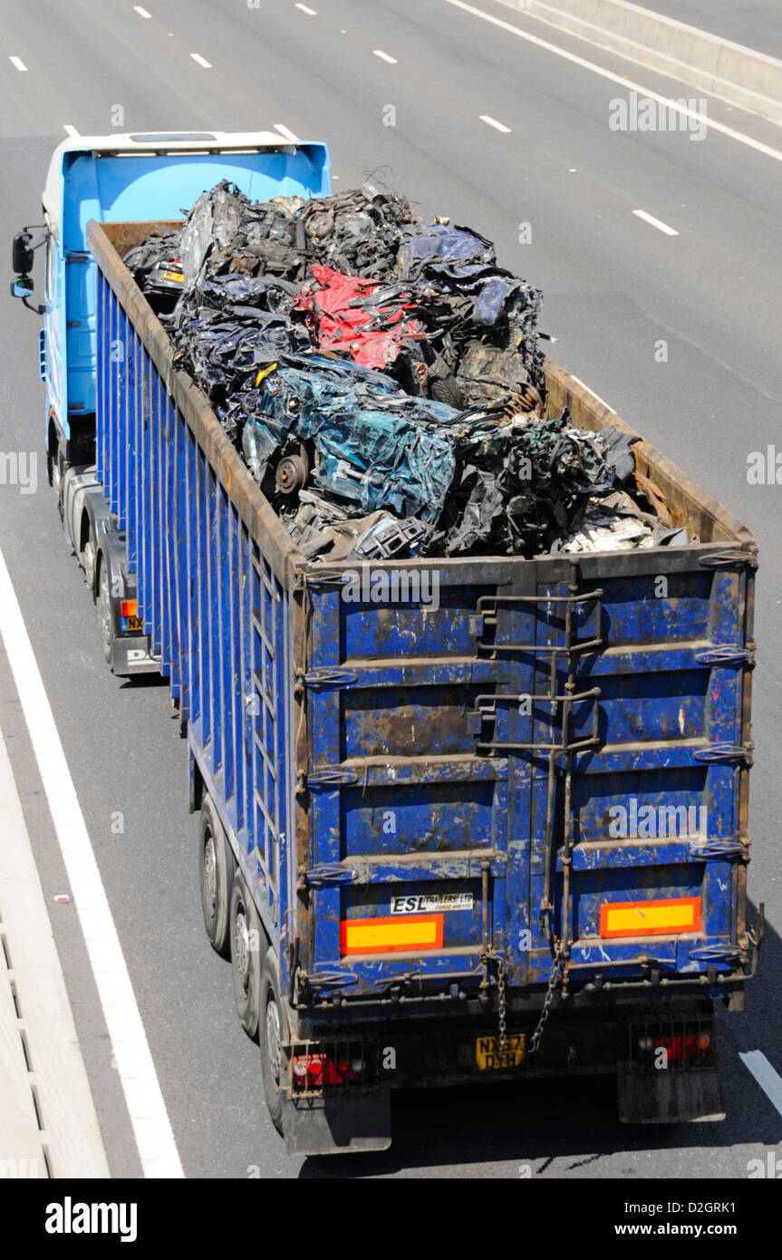 Vue en hauteur sur camion hgv, chargement de voitures à moteur broyées en ferraille dans une remorque articulée ouverte pour recyclage sur autoroute britannique Banque D'Images
