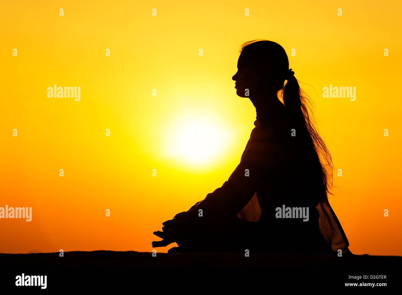 Sunset silhouette d'une jeune Indienne à méditer. L'Andhra Pradesh, Inde Banque D'Images