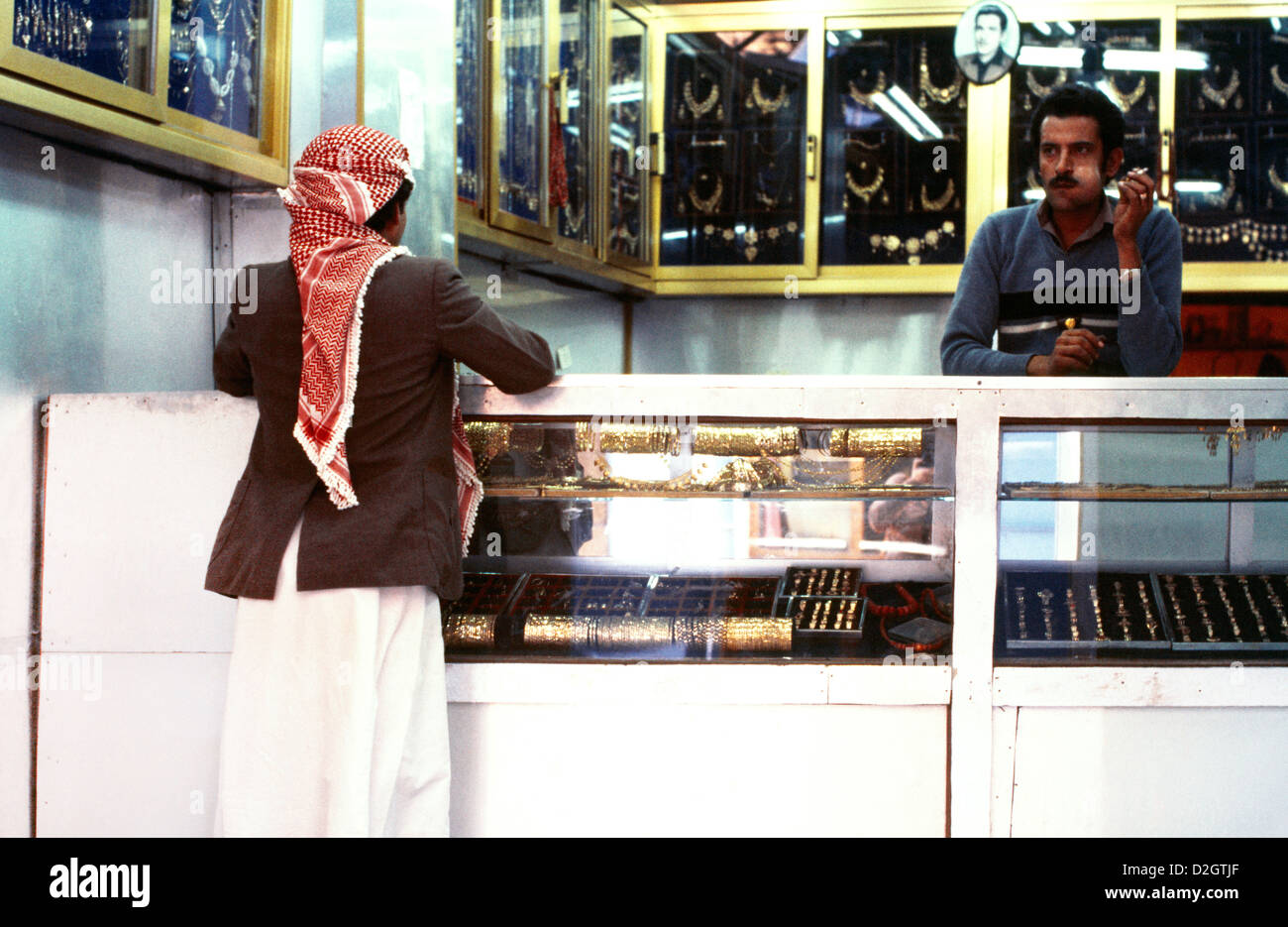 Sanaa Yémen Souk hommes dans la bijouterie homme derrière Counter Chewing QAT Client portant rouge et blanc Shemagh Banque D'Images