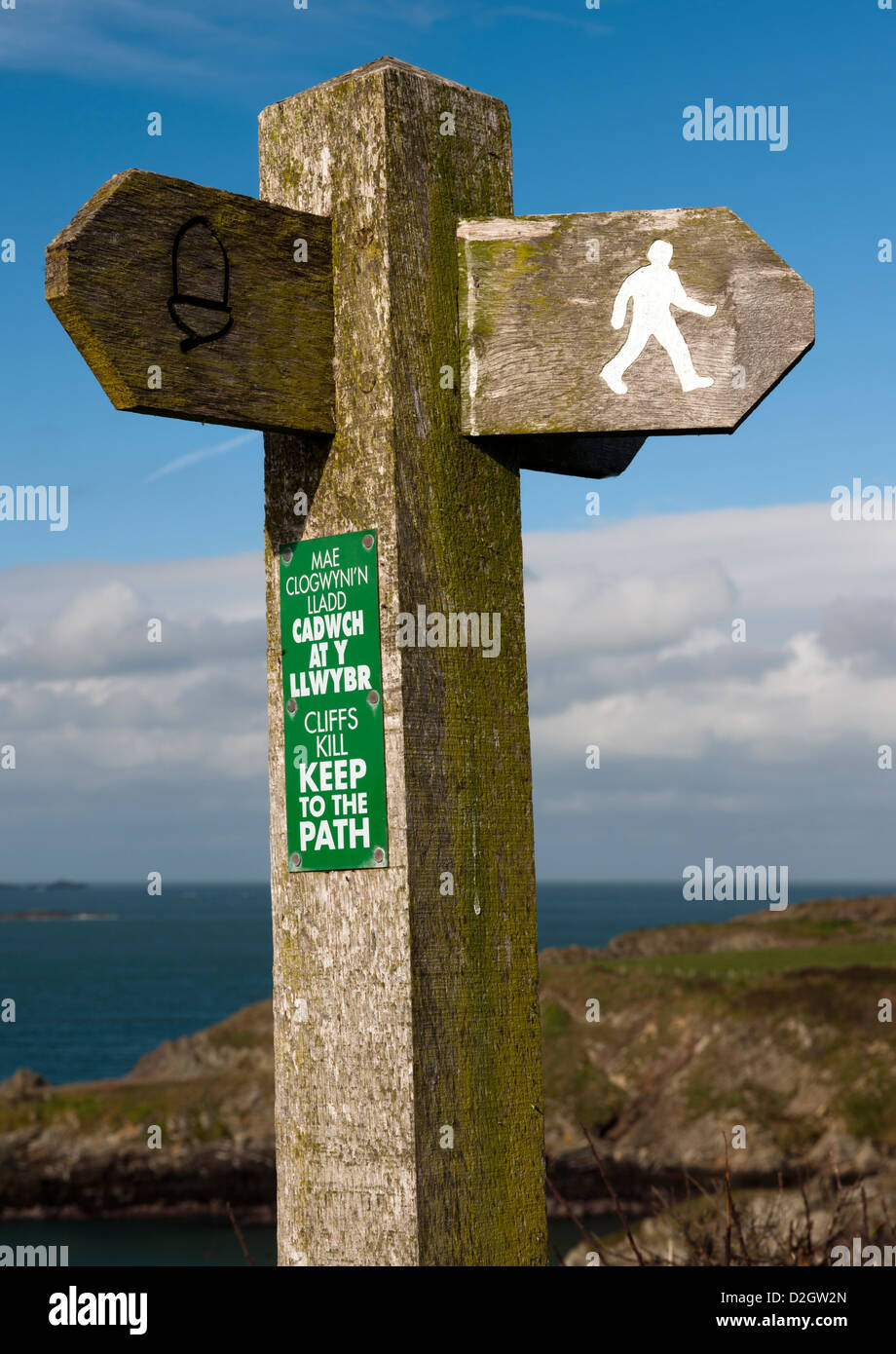 Les marcheurs, le Pays de Galles fingerpost directionnel Sentier du littoral La région E, Pembrokeshire, Pays de Galles, Royaume-Uni. Banque D'Images