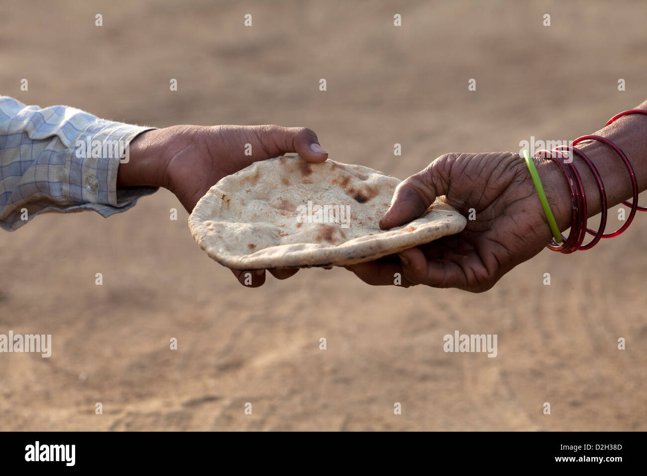 L'Inde, Uttar Pradesh, Agra, jeune garçon qui part accordée roti (Chapati) par la main de mère Banque D'Images