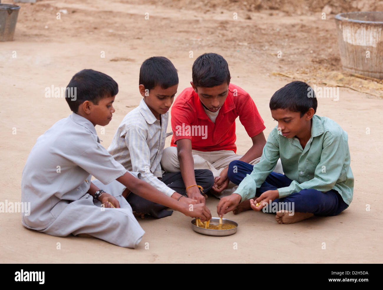 L'Inde, l'Uttar Pradesh, Agra jeunes enfants mangeant dal avec puces de style occidental Banque D'Images