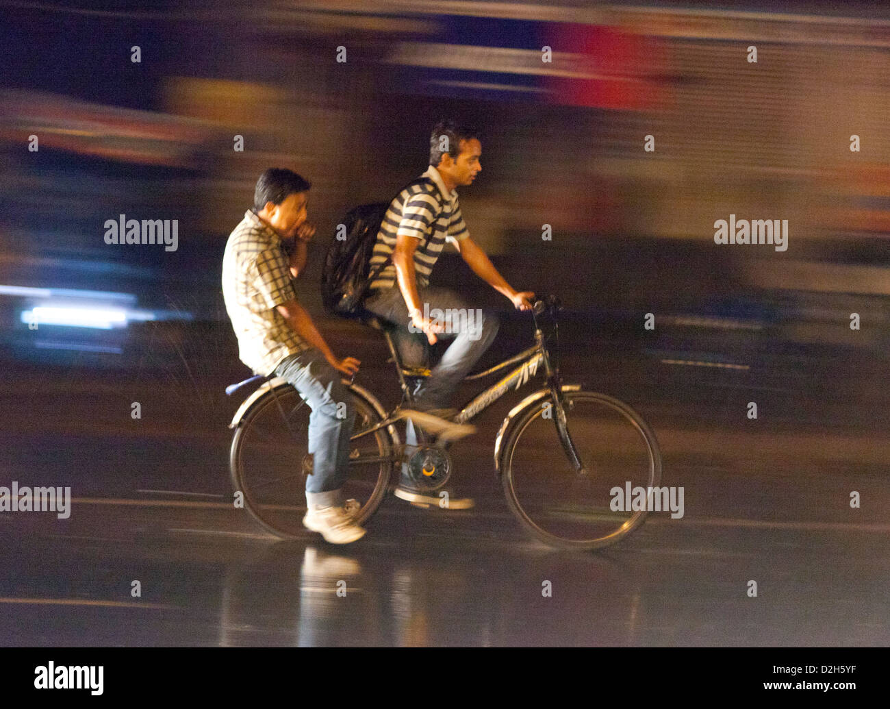 L'Inde, Uttar Pradesh, Agra deux hommes à vélo dans de fortes pluies de mousson Banque D'Images