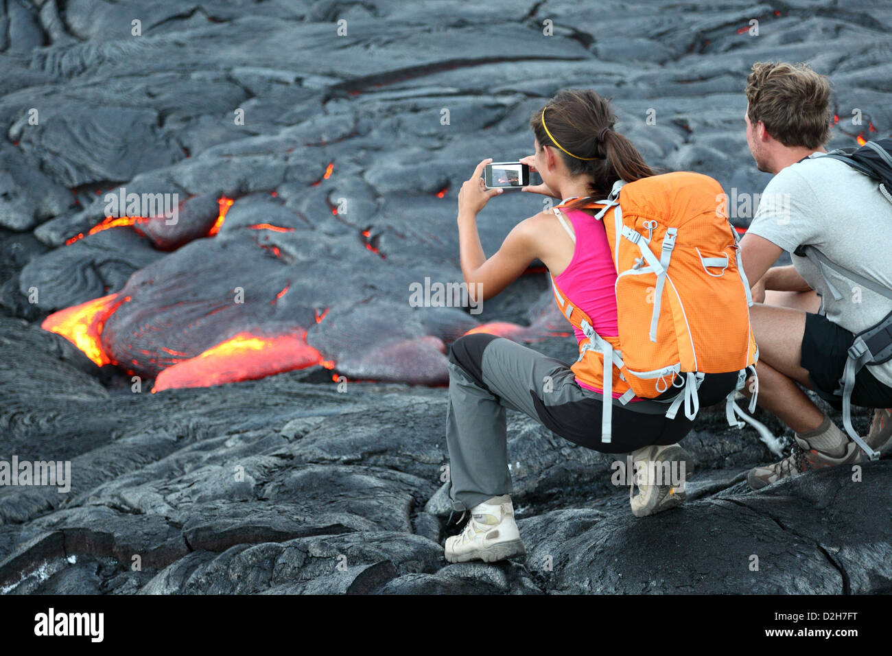 Les touristes de prendre des photos à partir de la lave qui coule autour de volcan Kilauea Hawaii Volcanoes National Park, États-Unis Banque D'Images