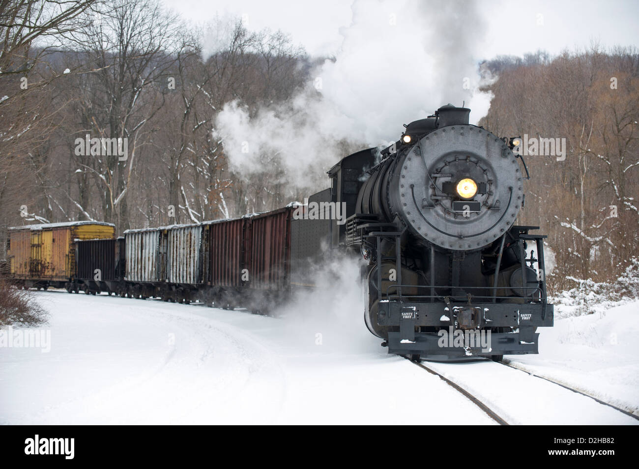 Train à vapeur locomotive tirant courbe arrondi en hiver neige poussant strong panache de fumée, reconstitution historique, près de Cumberland, Banque D'Images