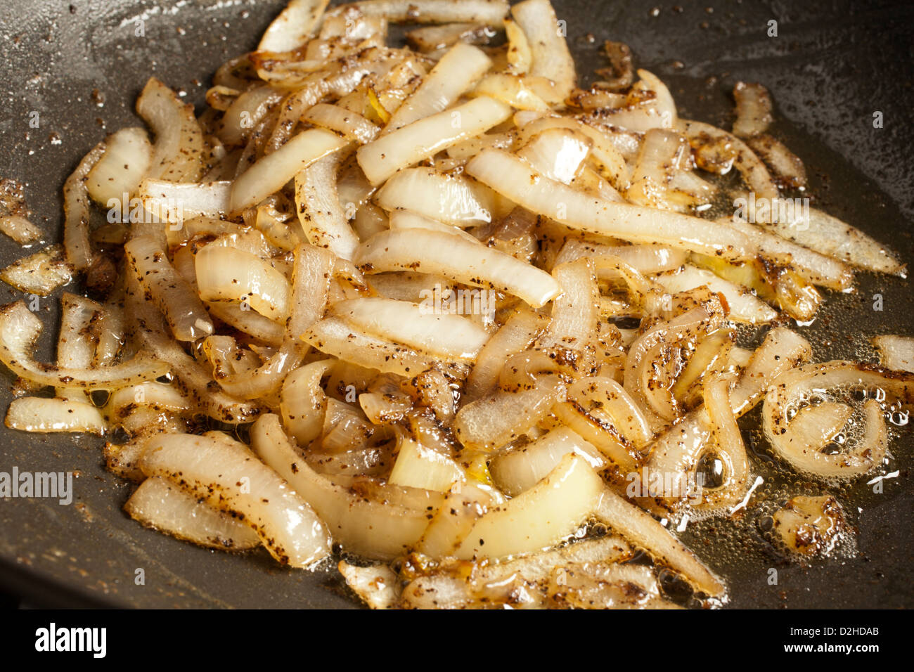 Frire les oignons dans une grande casserole Banque D'Images