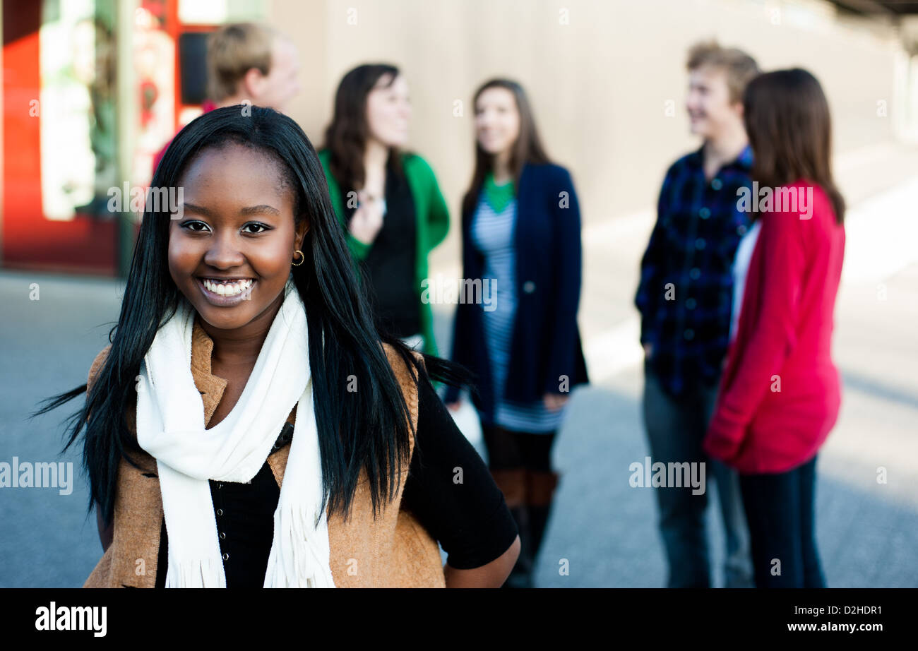 Jeune femme avec un groupe d'amis en souriant à l'extérieur Banque D'Images