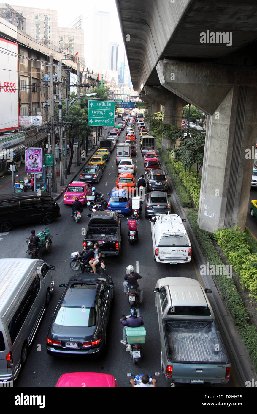 Quartier Sukhumvit , Bangkok, Thaïlande. Feux de circulation attendent à changer. Voitures, camionnettes, motos et scooters. Banque D'Images