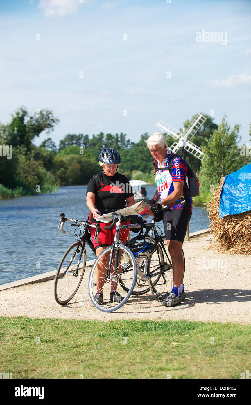 Les cyclistes masculins et féminins à la colline sur les Norfolk Broads sur un cycle touring holiday Banque D'Images