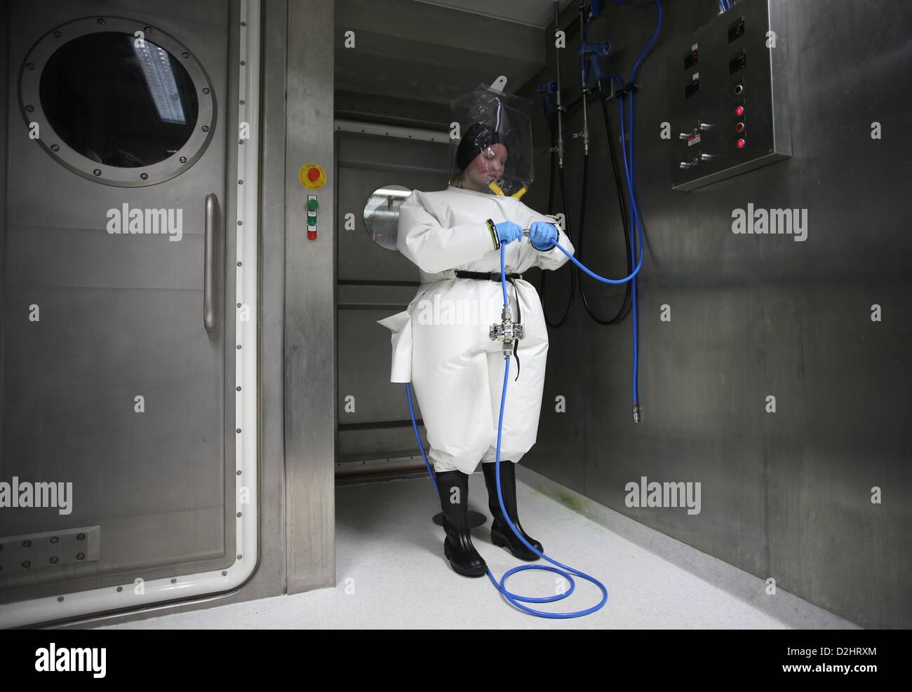 Lisa virologue Oestereich détient des vêtements protecteurs comme elle se tient dans la serrure de la nouvelle sécurité biologique de niveau 4 de l'Institut Bernhard Nocht for Tropical Medicine (BNI) à Hambourg, Allemagne, 25 janvier 2013. Le nouveau labroratory contribuera à la recherche de l'Institut sur les maladies tropicales, y compris des maladies dangereuses comme la fièvre de Lassa, la fièvre Ebola, Marburg et la leishmaniose. Photo : CHRISTIAN CHARISIUS Banque D'Images