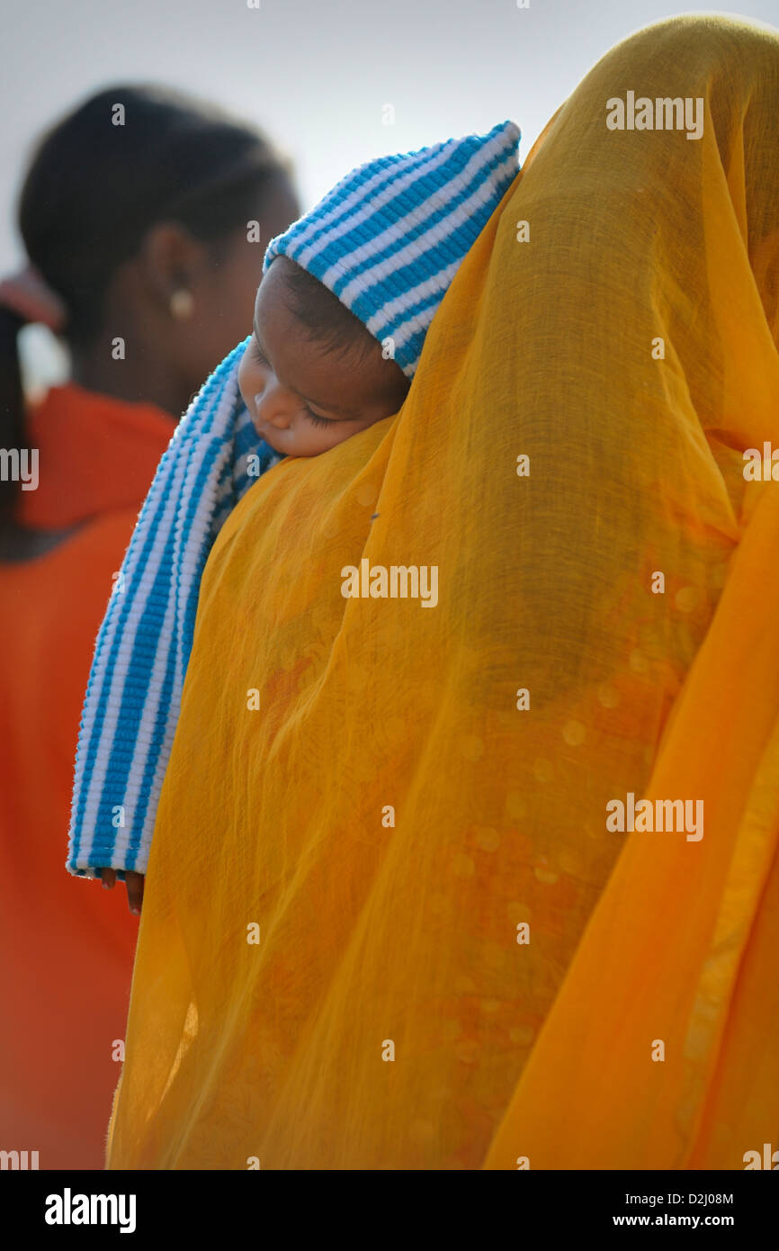 Vue arrière d'un vêtu de façon traditionnelle indienne carrying baby Banque D'Images