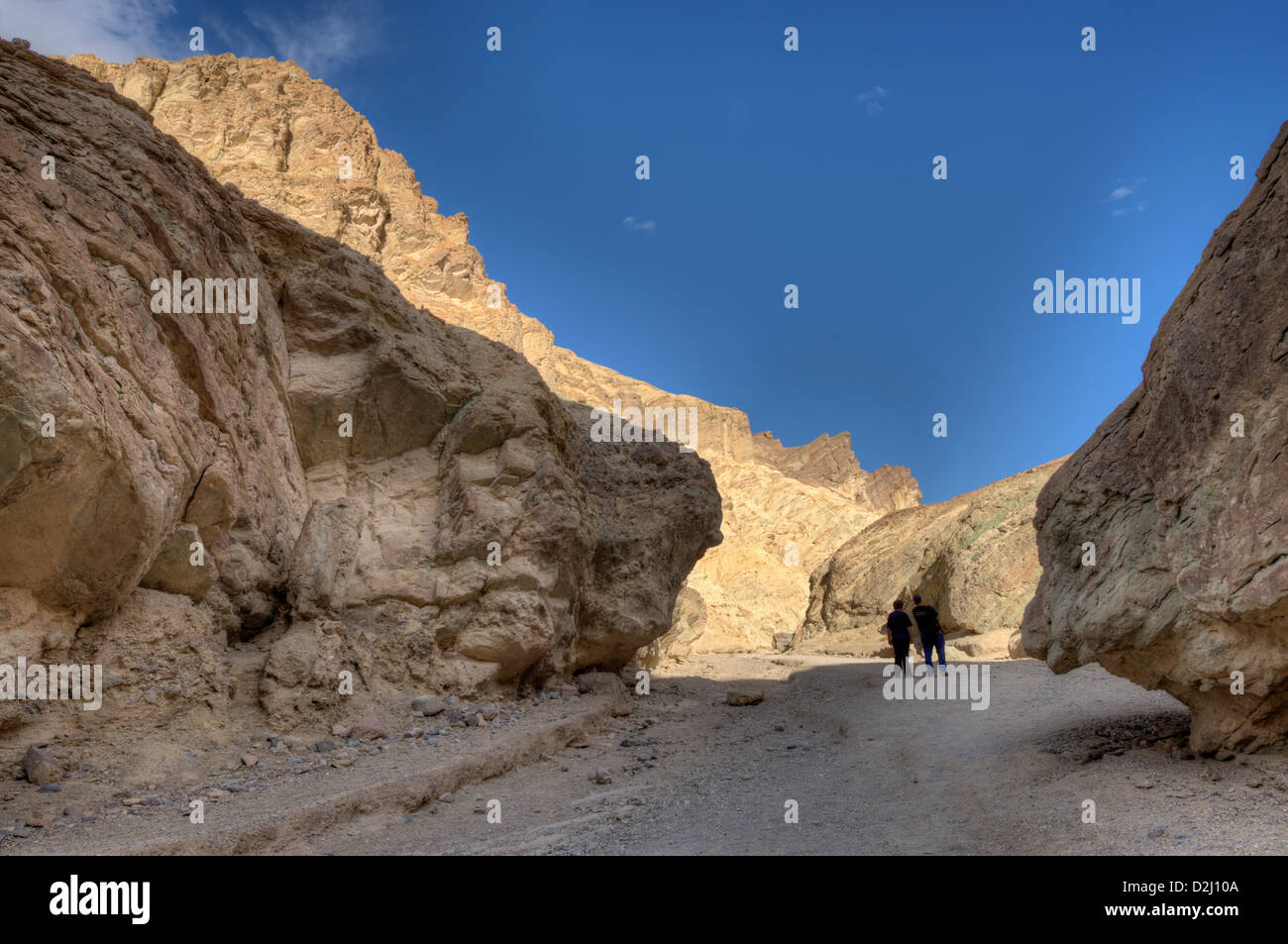 Un jeune couple se penche sur l'étrangeté géologique de la Death Valley National Park's Golden Canyon Banque D'Images