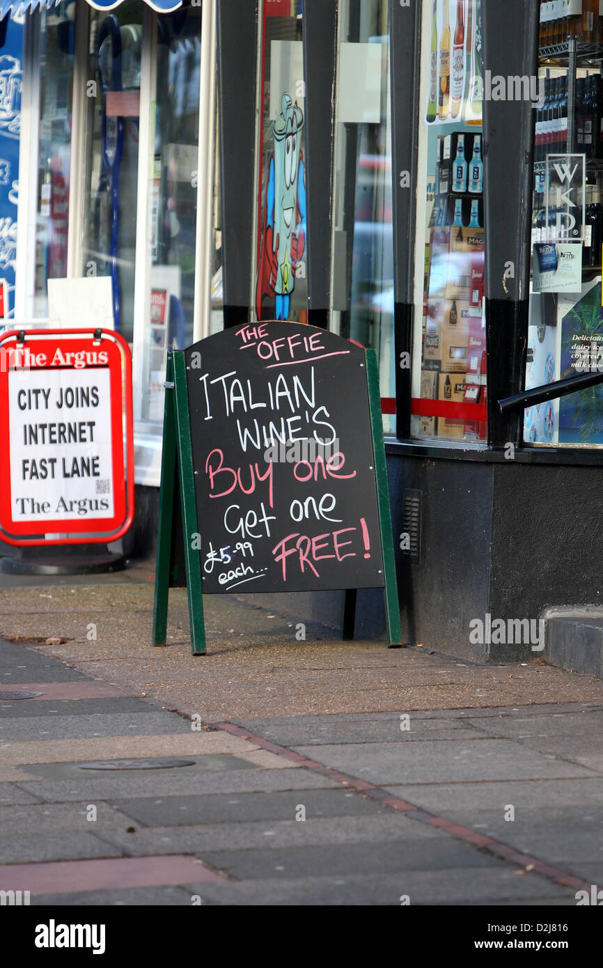 Panneau indiquant une offre pour acheter une bouteille de vin et d'obtenir une licence libre en dehors d'un arrêt à Brighton, East Sussex, UK. Banque D'Images