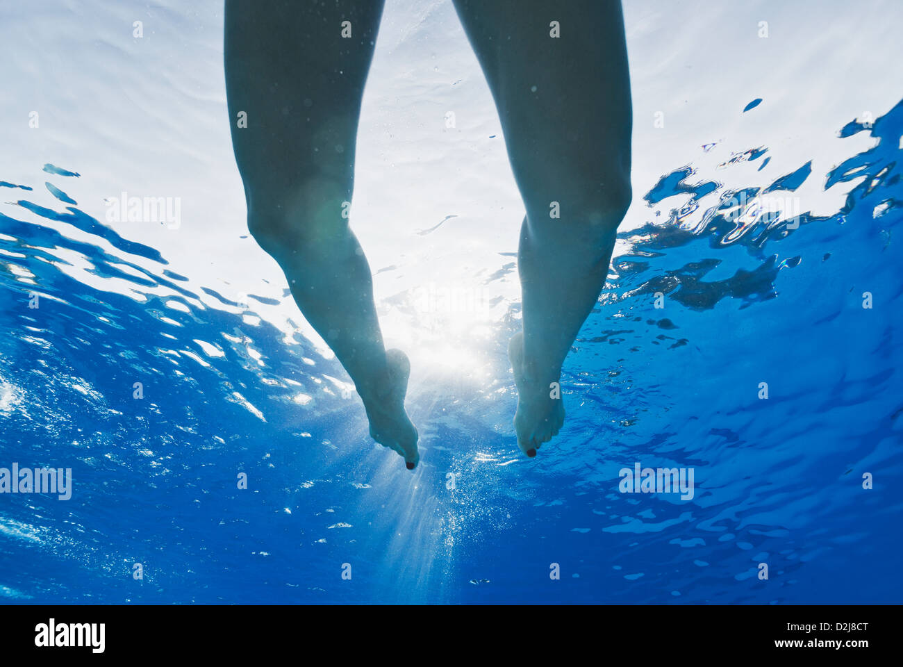 Les jambes de nager dans une piscine avec la lumière du soleil qui brillait à travers l'eau ; tarifa cadiz andalousie espagne Banque D'Images