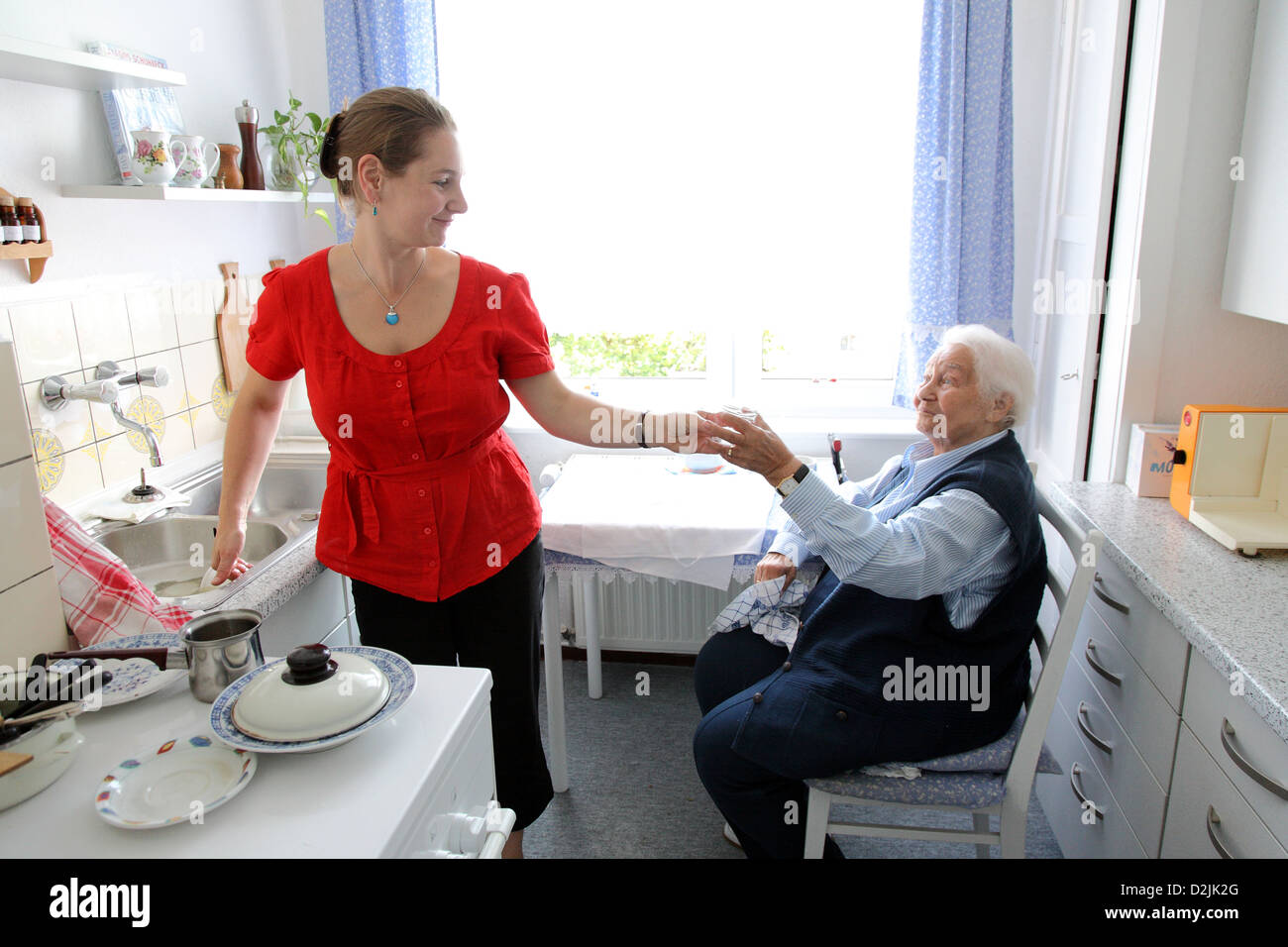 Berlin, Allemagne, une jeune femme d'aider une femme âgée washing up Banque D'Images