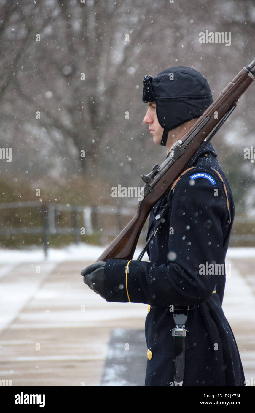Tombeau des inconnus Sentinel Snow Arlington Virginie // ARLINGTON, Virginie — Un soldat monte la garde sur le tombeau des inconnus au cimetière national d'Arlington pendant une chute de neige. La sentinelle du 3rd U.S. Infantry Regiment maintient la veille cérémonielle malgré les conditions météorologiques hivernales. Le garde suit une routine précise de 21 étapes, marchant le long du tapis noir derrière la tombe avant de tourner et de faire face à l'est pendant 21 secondes, puis au nord pendant 21 secondes. La tombe du soldat inconnu est gardée en permanence 24 heures sur 24, 365 jours par an depuis 1937. Banque D'Images