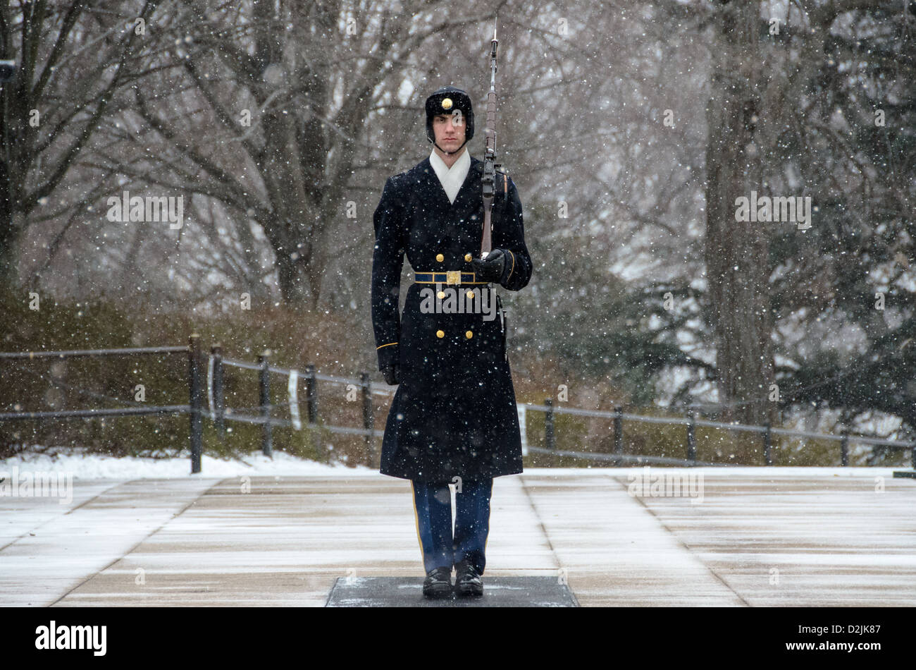 Tombeau du soldat inconnu Sentinel neige Arlington Virginie // ARLINGTON, Virginie — Un soldat monte la garde sur le tombeau des inconnus au cimetière national d'Arlington pendant une chute de neige. La sentinelle du 3rd U.S. Infantry Regiment maintient la veille cérémonielle malgré les conditions météorologiques hivernales. Le garde suit une routine précise de 21 étapes, marchant le long du tapis noir derrière la tombe avant de tourner et de faire face à l'est pendant 21 secondes, puis au nord pendant 21 secondes. La tombe du soldat inconnu est gardée en permanence 24 heures sur 24, 365 jours par an depuis 1937. Banque D'Images