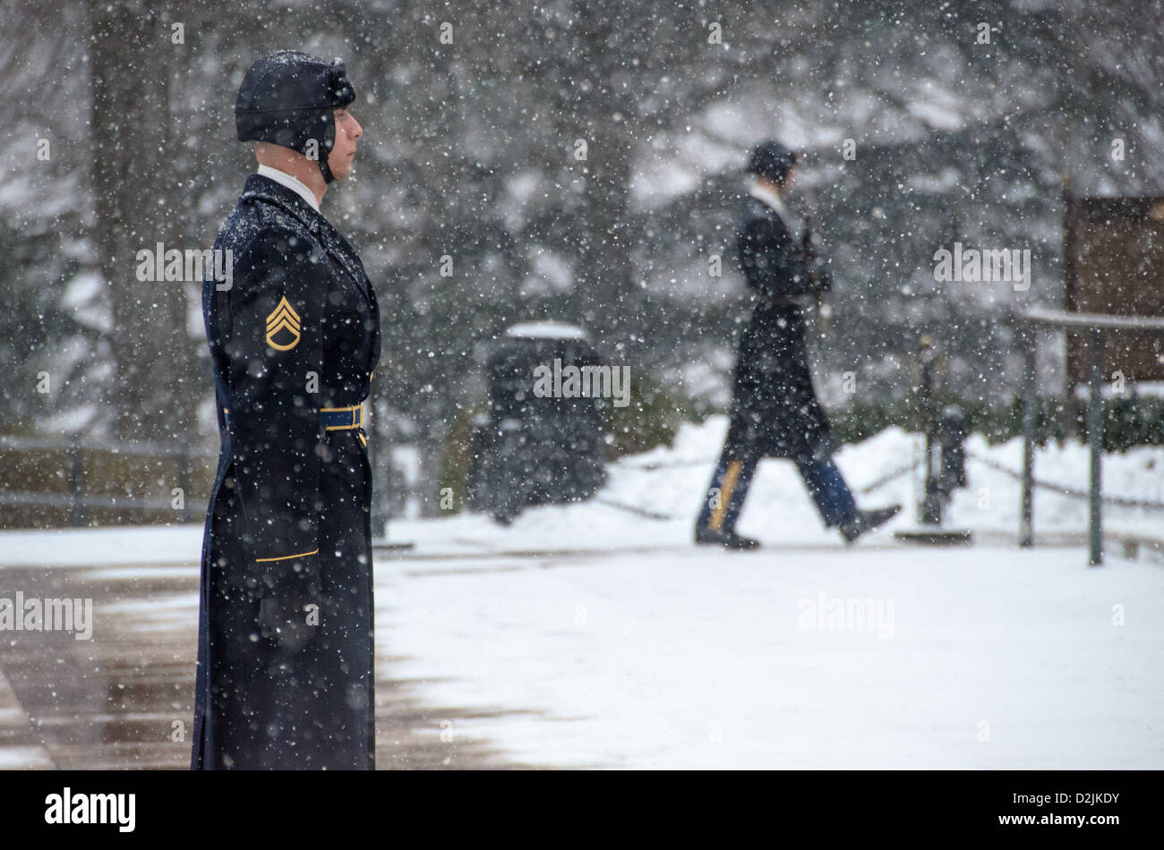 Tombe de la Garde des soldats inconnus à Snow Arlington Virginie // ARLINGTON, Virginie — Un soldat monte la garde à la tombe des inconnus au cimetière national d'Arlington pendant une chute de neige. La sentinelle du 3rd U.S. Infantry Regiment maintient la veille cérémonielle malgré les conditions météorologiques hivernales. Le garde suit une routine précise de 21 étapes, marchant le long du tapis noir derrière la tombe avant de tourner et de faire face à l'est pendant 21 secondes, puis au nord pendant 21 secondes. La tombe du soldat inconnu est gardée en permanence 24 heures sur 24, 365 jours par an depuis 1937. Banque D'Images