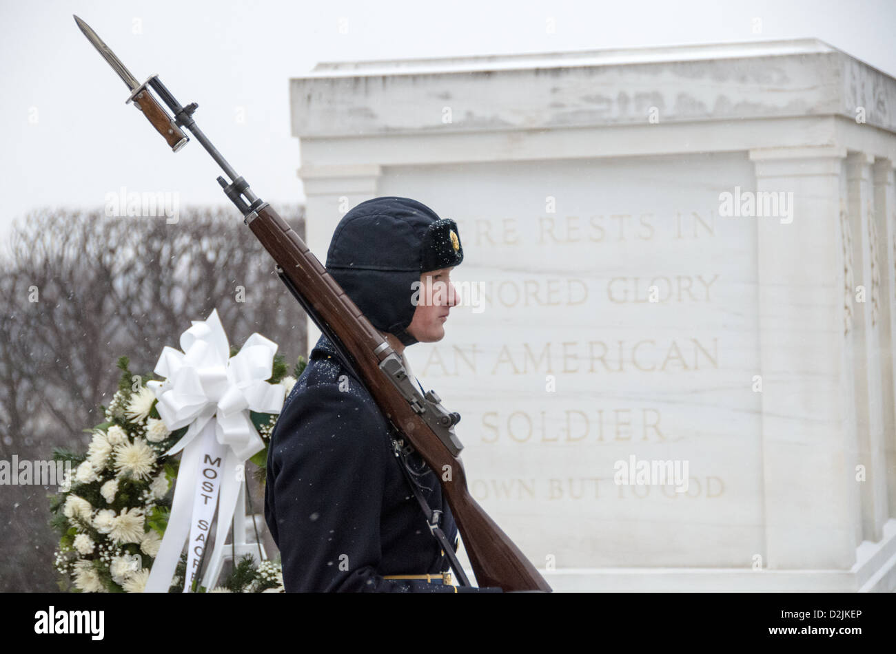 Un soldat prend part à la cérémonie de relève de la garde devant la tombe de l'inconnu au cimetière national d'Arlington dans la neige. Il est en passant en face de la tombe, avec l'inscription inscription. Banque D'Images