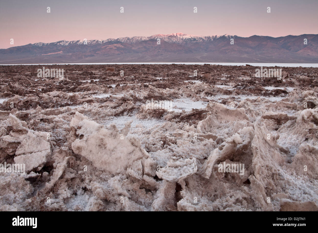 Des cristaux de sel à Badwater ci-dessous début de lumière sur la Panamint Range, Death Valley National Park, en Californie. Banque D'Images