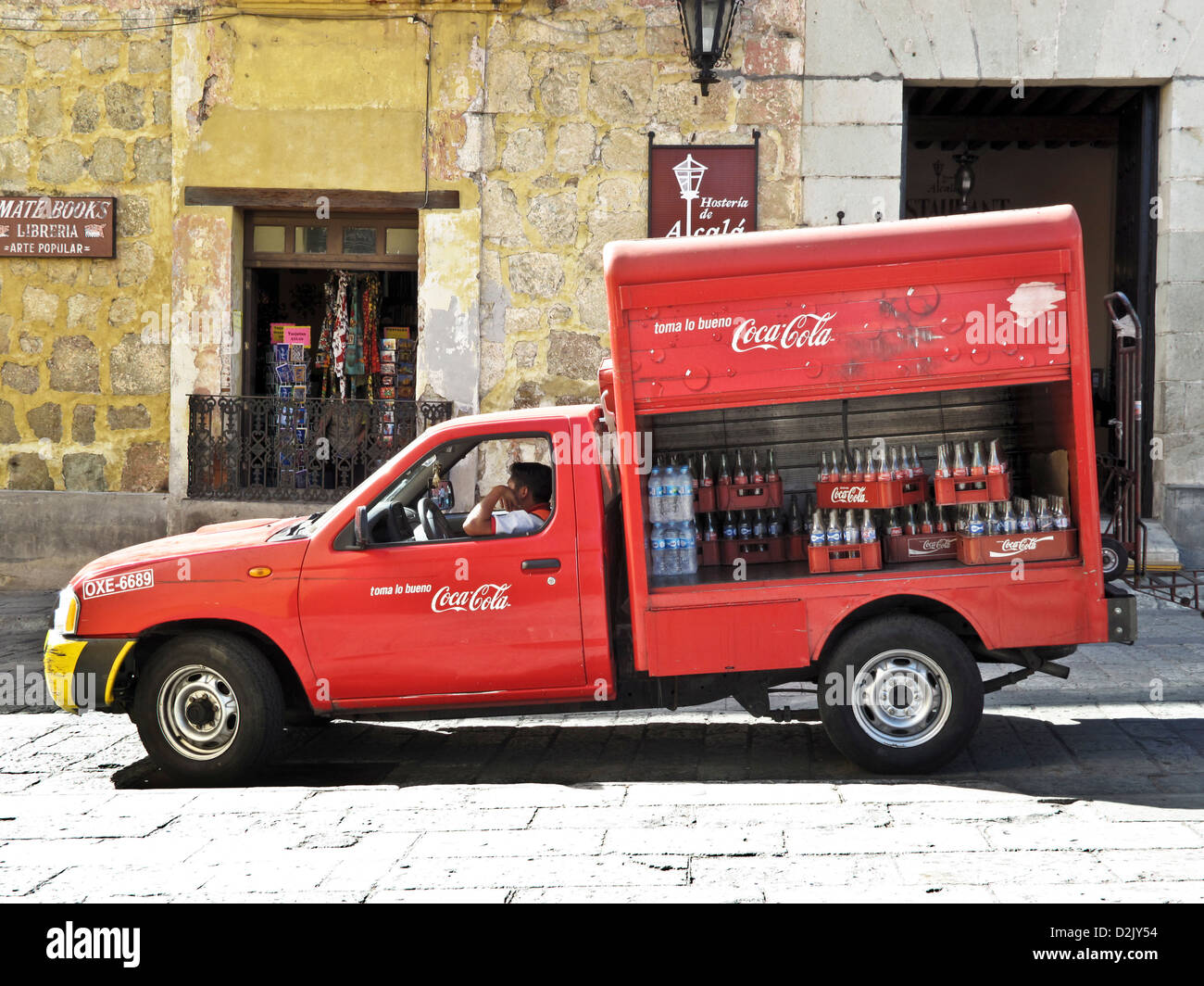 Coca Cola rouge camion avec panneaux latéraux ouverts révélant les caisses de bouteilles vides en faisant une livraison à Oaxaca de Juarez, Mexique Banque D'Images