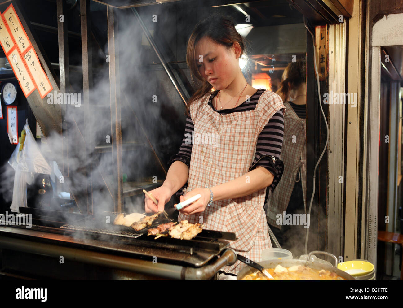 Tokyo, Japon, une femme se prépare à brochettes de viande Banque D'Images