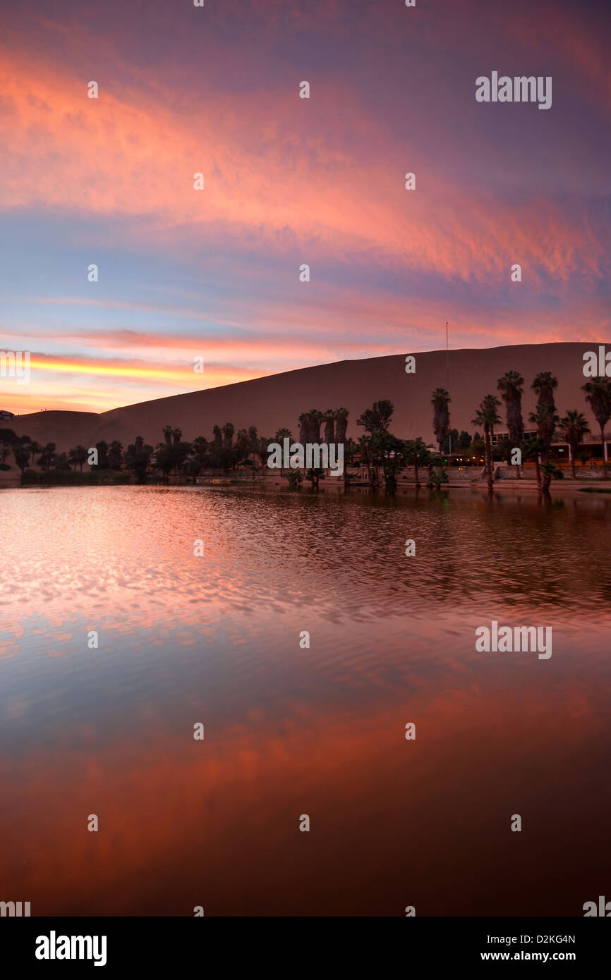 Coucher Soleil nuages reflètent dans une oasis au milieu du désert Banque D'Images
