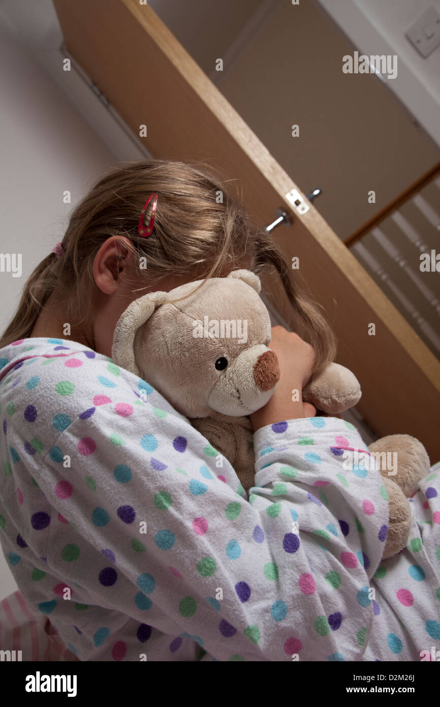 Jeune femme portant un pyjama serrant son ours en peluche. Banque D'Images