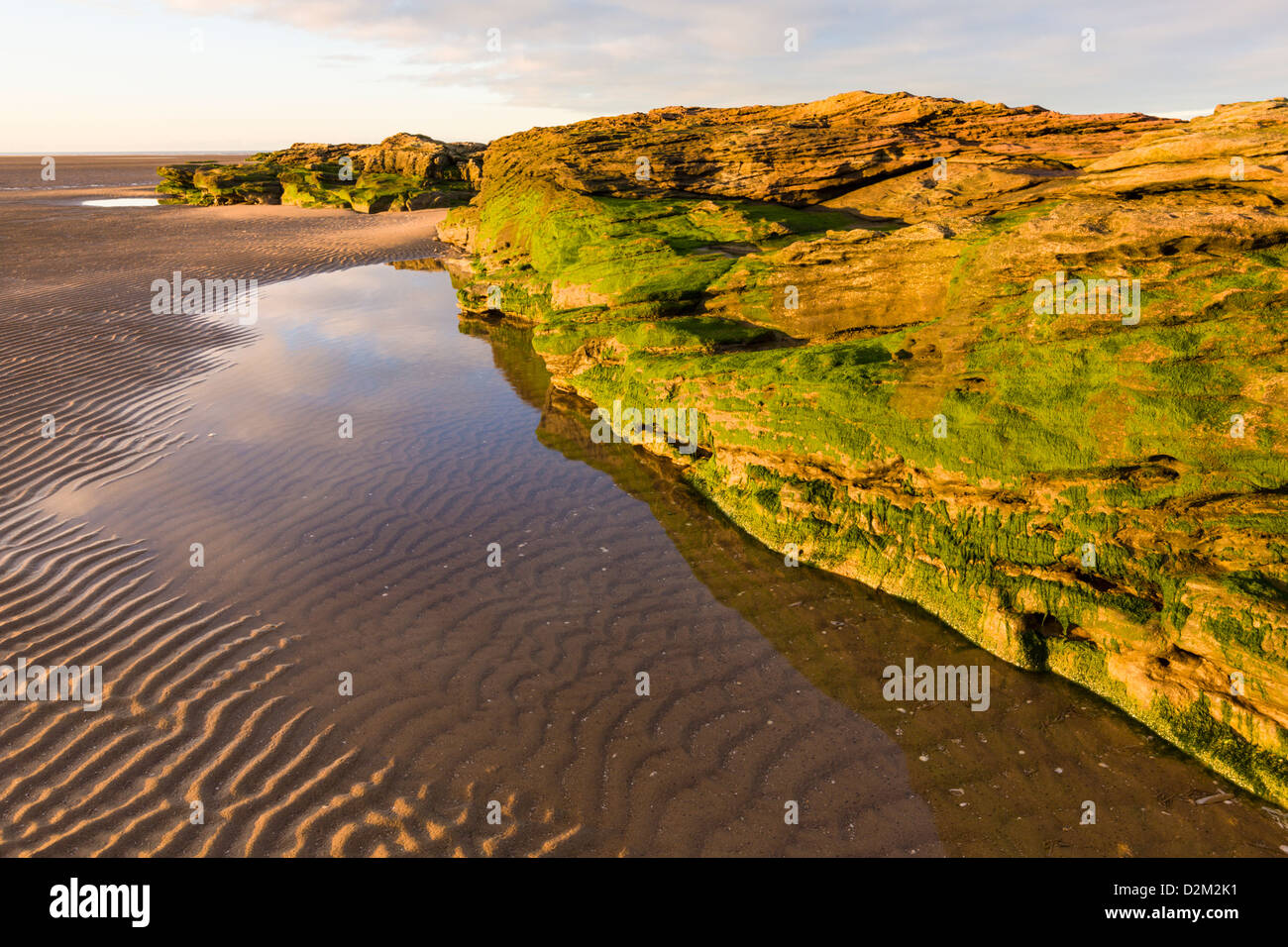 Rippled sand et rochers de grès à marée basse, Wirral, Angleterre Banque D'Images