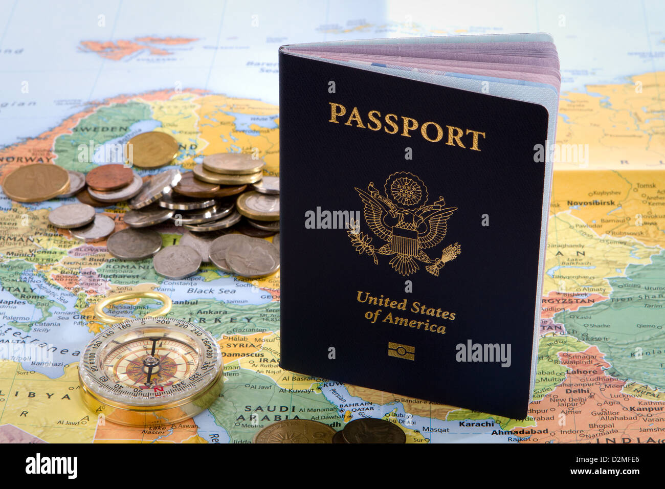 USA passeport, boussole et pièces de monnaie étrangère s'asseoir sur une carte d'Europe pour un voyage international concept. Banque D'Images