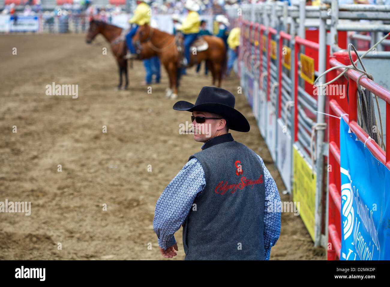 Un cowboy fume son cigare en regardant la concurrence monte Banque D'Images