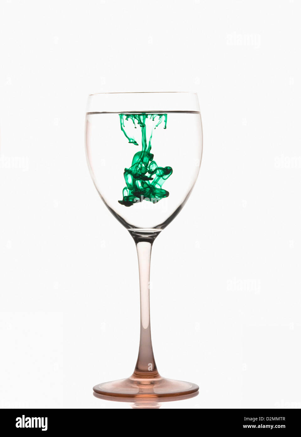 Des stries de couleur verte avec de l'eau dans un verre à vin Banque D'Images