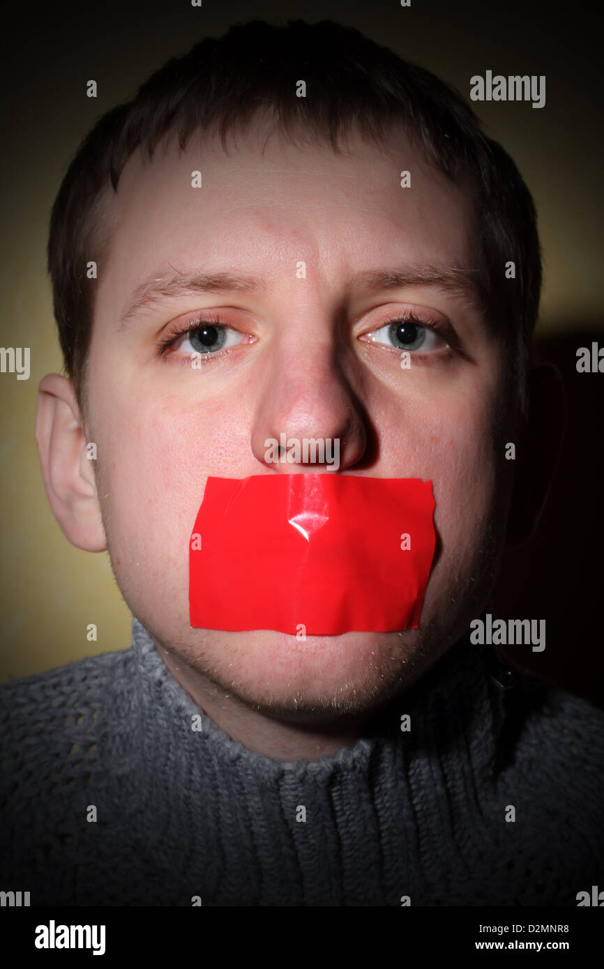 L'homme se ferme sa bouche la paperasserie, creative, symbolisant la lutte pour la liberté d'expression et contre la censure Banque D'Images